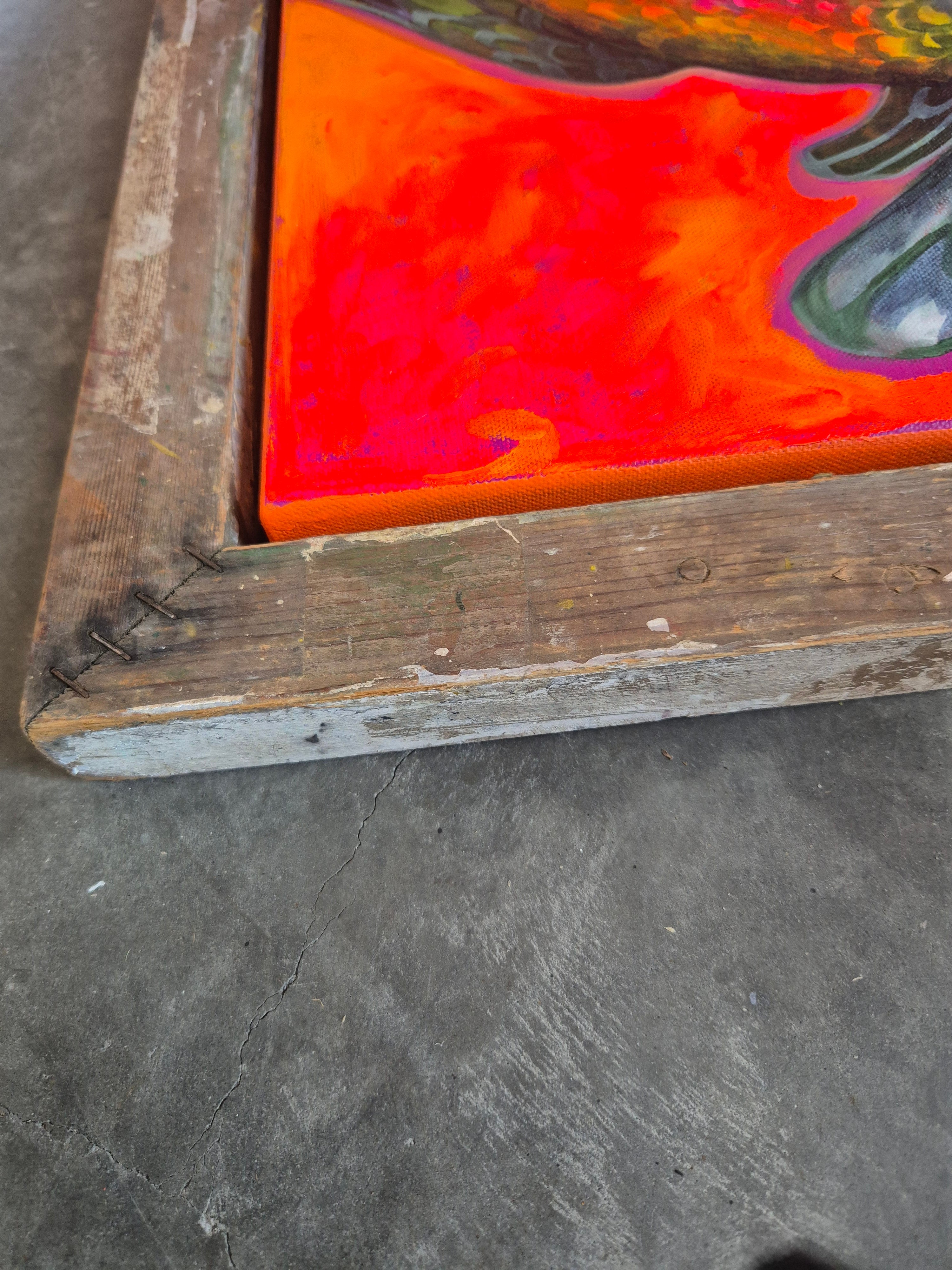 Close-up of a colorful glass panel with a wooden frame on a concrete surface